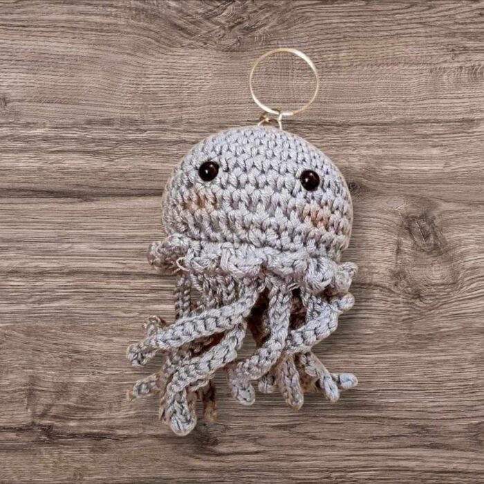 porte-Clé pieuvre grise douceur et d’originalité à vos clés ou sacs avec ce porte-clés pieuvre fait main au crochet ! Confectionné avec soin à partir de fils de haute qualité, il est à la fois mignon, léger et résistant. Ses petites tentacules apportent une texture agréable au toucher, parfait pour un cadeau unique ou pour vous faire plaisir.